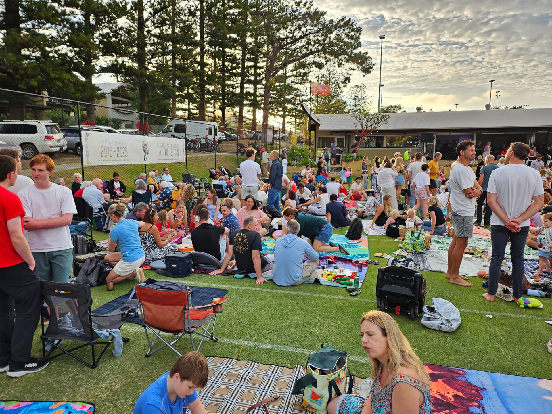 Families picnicking on the grass courts at the Allen Park Christmas Carols