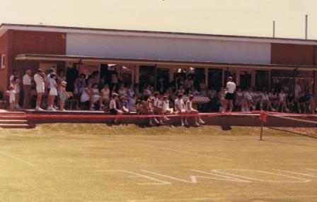 A crowd of members lining the verandah and courtside for the opening of the new courts.
