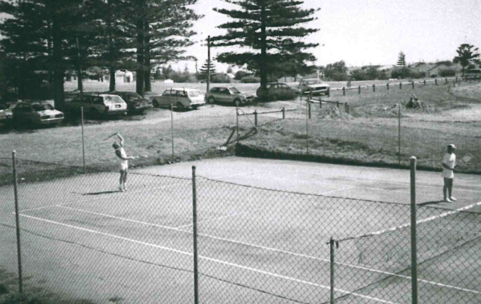 Players on one of the new hard courts at Allen Park in 1985, with Norfolk Pines in the background.